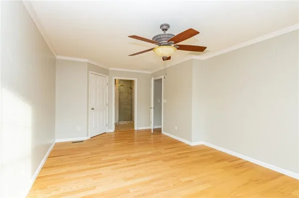 a view of a big room with wooden floor and a ceiling fan