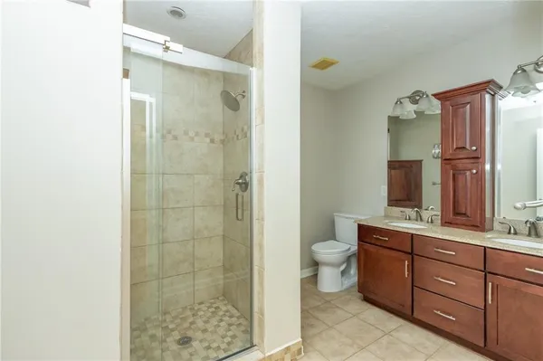 a bathroom with a double vanity sink toilet and shower