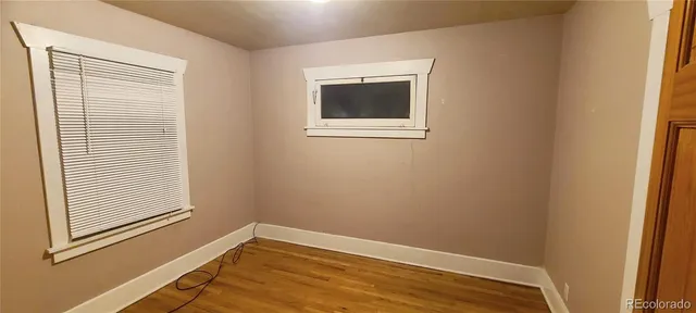 a view of a room with wooden floor and a window