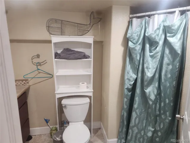 a bathroom with a toilet sink vanity and mirror