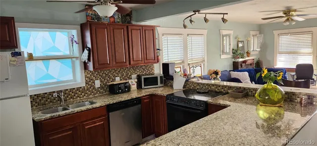 a kitchen with stainless steel appliances granite countertop a sink stove and cabinets