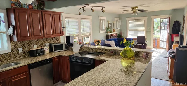 a kitchen with stainless steel appliances granite countertop sink stove top oven and cabinets