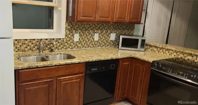 a kitchen with stainless steel appliances granite countertop a sink stove and microwave