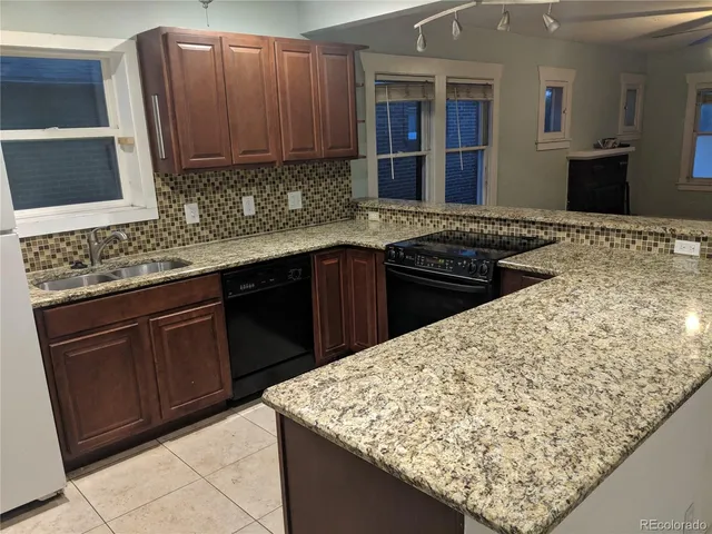 a kitchen with stainless steel appliances granite countertop wooden cabinets and a sink