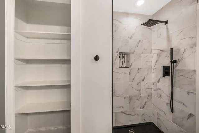 an empty room with ceiling fan and windows