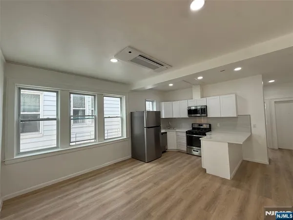 a kitchen with a refrigerator and a stove top oven