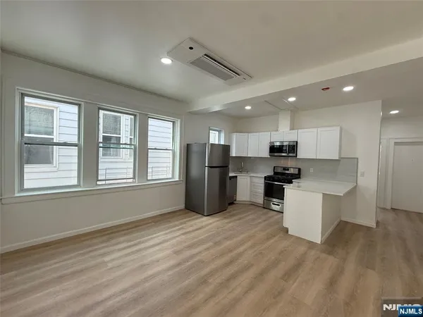 a kitchen with stainless steel appliances kitchen island wooden cabinets and refrigerator