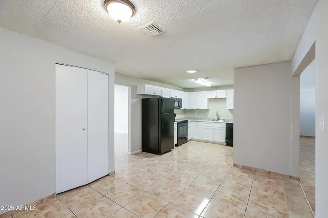 a view of a kitchen with refrigerator and a sink