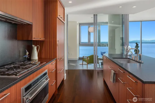 a kitchen with kitchen island granite countertop a stove and a sink
