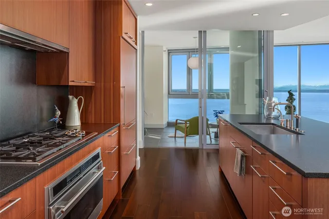 a kitchen with kitchen island granite countertop a stove and a sink