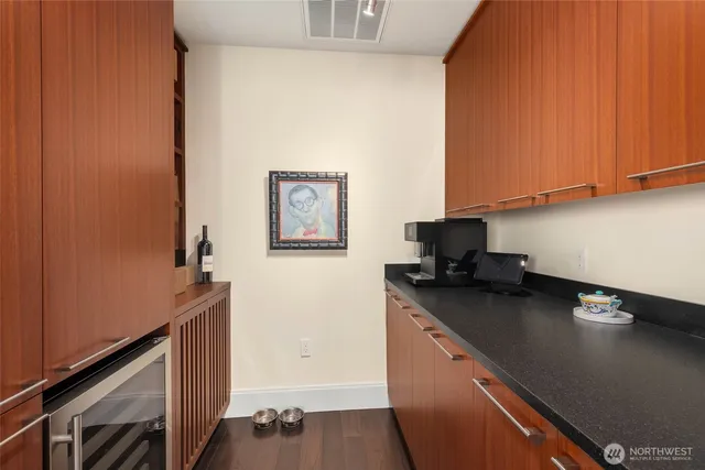 a kitchen with stainless steel appliances a sink a stove wooden floor and cabinets