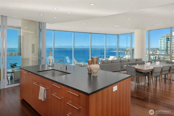 a kitchen with kitchen island granite countertop a sink a counter top space and living room view