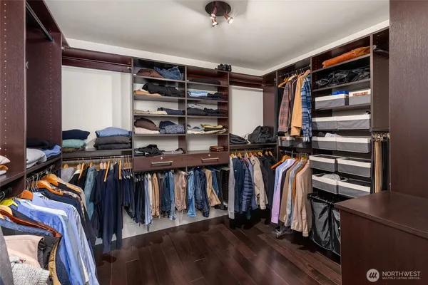 a view of walk in closet with clothes and shoes