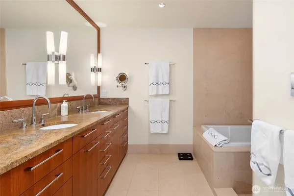 a spacious bathroom with a double vanity sink a mirror and a bathtub