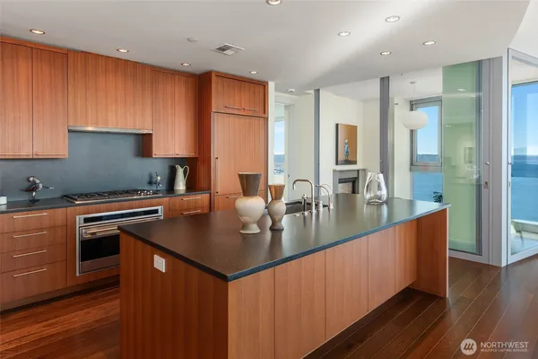 a kitchen with stainless steel appliances granite countertop a sink a stove and a refrigerator