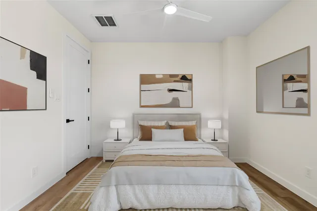 a bedroom with a bed and painting on the wall