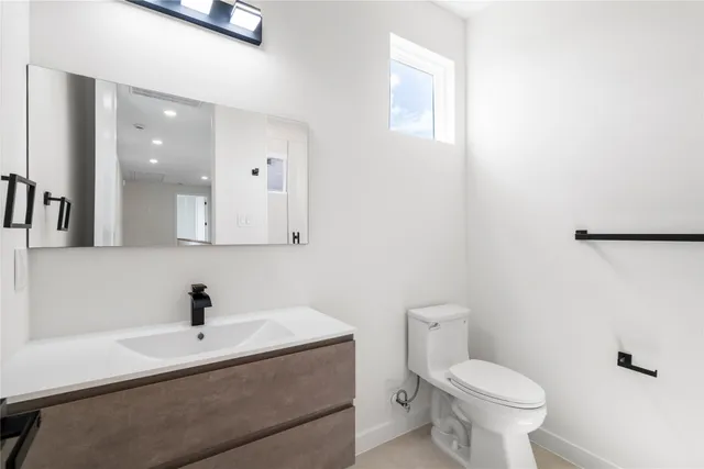 a bathroom with a sink a toilet and mirror