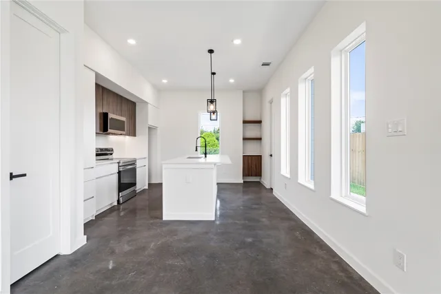 a view of kitchen with stove refrigerator and microwave