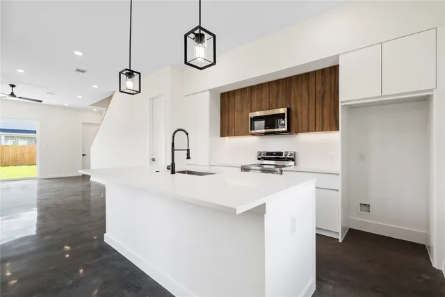 a kitchen with a sink a microwave a stove and refrigerator
