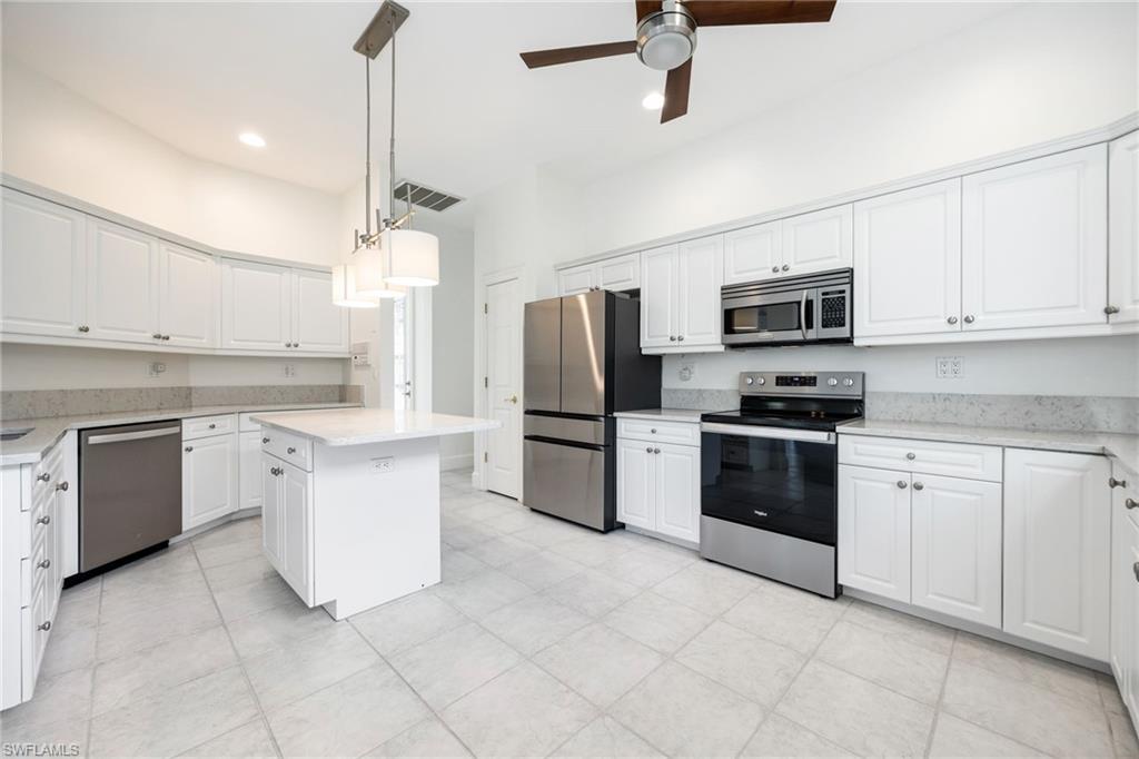 982 Fountain Run Naples, FL 34119 - Photo 11 of 44 Kitchen featuring stainless steel appliances, white cabinetry, a ceiling fan, and light stone countertops