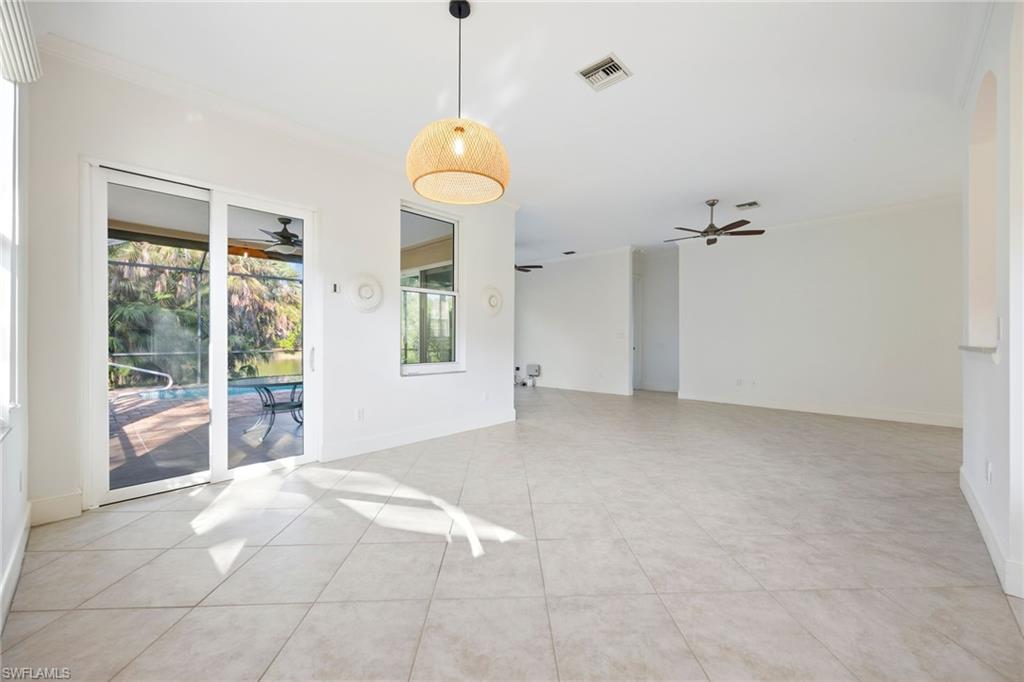 982 Fountain Run Naples, FL 34119 - Photo 16 of 44 Empty room with crown molding, ceiling fan, a sunroom, and light tile patterned floors