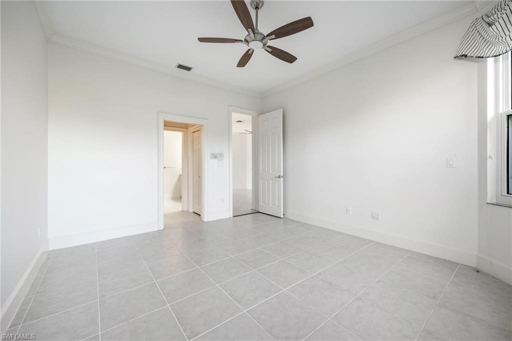 982 Fountain Run Naples, FL 34119 - Photo 20 of 44 Unfurnished bedroom with crown molding, a ceiling fan, and light tile patterned floors