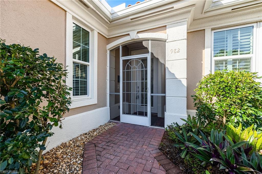 982 Fountain Run Naples, FL 34119 - Photo 2 of 44 Entrance to property featuring a sunroom and stucco siding