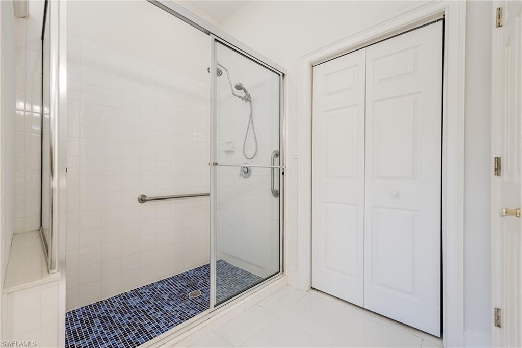 982 Fountain Run Naples, FL 34119 - Photo 24 of 44 Full bathroom with a closet, a stall shower, and light tile patterned floors