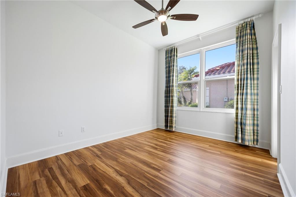 982 Fountain Run Naples, FL 34119 - Photo 25 of 44 Unfurnished room featuring wood finished floors, ceiling fan, and lofted ceiling