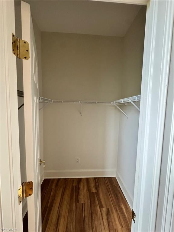 982 Fountain Run Naples, FL 34119 - Photo 26 of 44 Walk in closet featuring dark wood-type flooring