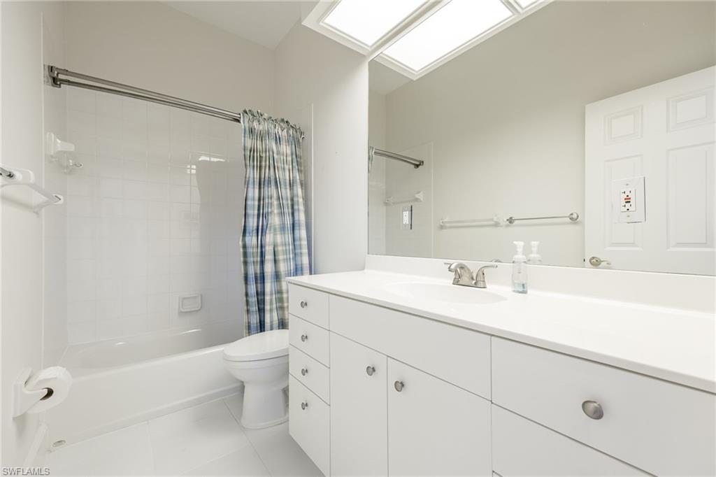982 Fountain Run Naples, FL 34119 - Photo 27 of 44 Full bathroom featuring vanity, shower / tub combo, light tile patterned floors, and a skylight