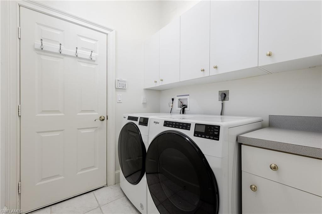 982 Fountain Run Naples, FL 34119 - Photo 28 of 44 Laundry area featuring cabinet space, light tile patterned floors, and washer and dryer