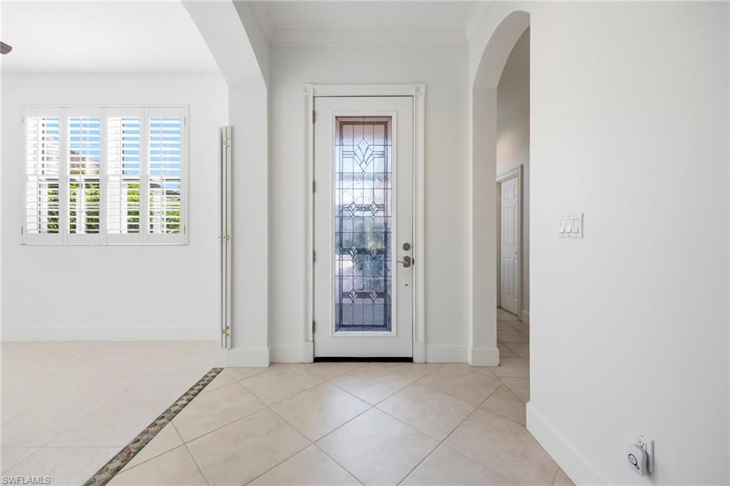 982 Fountain Run Naples, FL 34119 - Photo 3 of 44 Entryway with arched walkways, light tile patterned floors, and ornamental molding