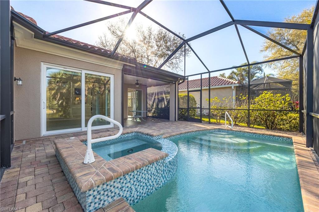 982 Fountain Run Naples, FL 34119 - Photo 31 of 44 Combined pool / hot tub featuring a patio area, a sunroom, and glass enclosure