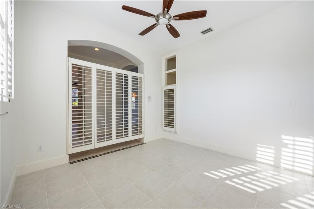 982 Fountain Run Naples, FL 34119 - Photo 5 of 44 Spare room with ceiling fan, light tile patterned floors, and built in features