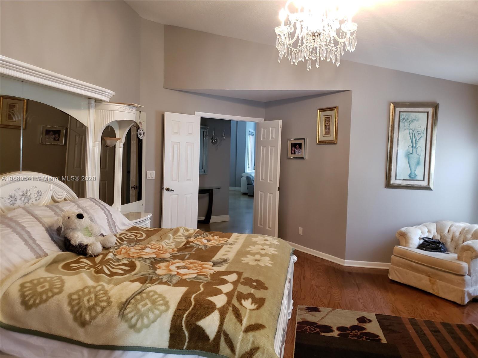 6466 Brava Way Boca Raton, FL 33433 - Photo 15 of 50 a bedroom with a bed and wooden floor