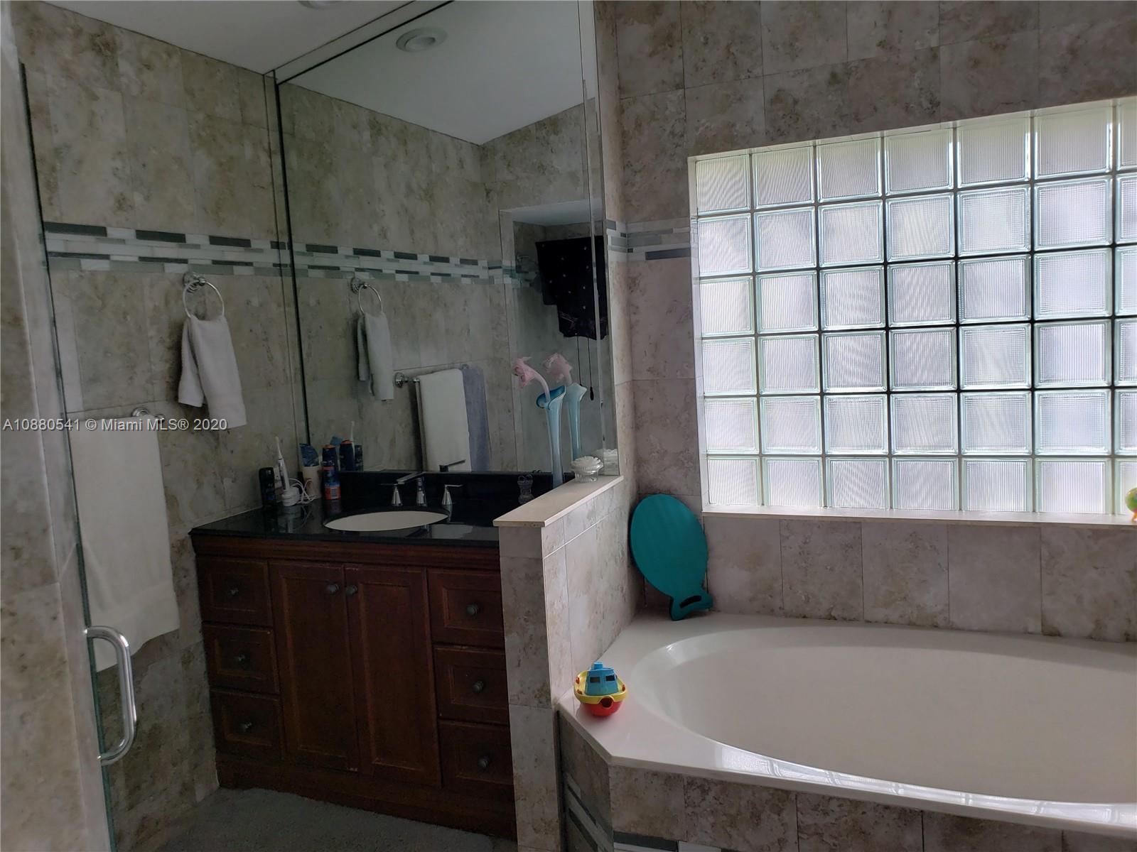 6466 Brava Way Boca Raton, FL 33433 - Photo 19 of 50 a bathroom with a bathtub and a window