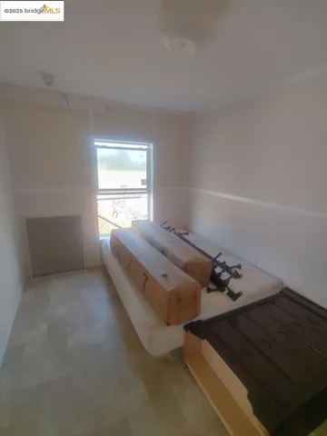 a view of a bedroom with furniture and window