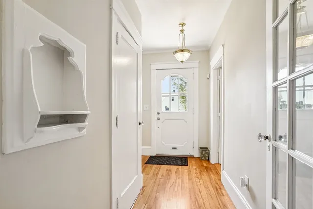 a view of a hallway with wooden floor and a bathroom