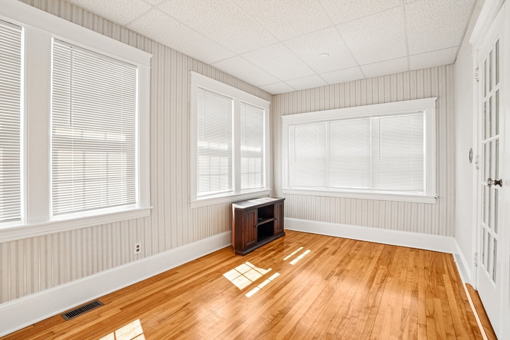 174 Park Avenue, Unit 1 Worcester, MA 01602 - Photo 12 of 34 an empty room with wooden floor and windows
