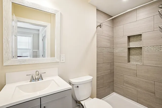 a bathroom with a sink a toilet and shower