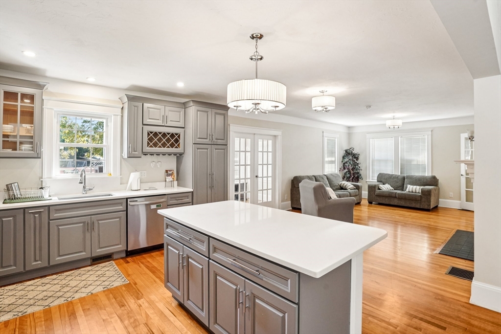 174 Park Avenue, Unit 1 Worcester, MA 01602 - Photo 7 of 34 a large white kitchen with a stove a sink dishwasher and a refrigerator with wooden floor