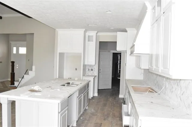 a kitchen that has a sink a stove and large window