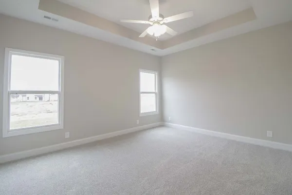 an empty room with a window and a fan