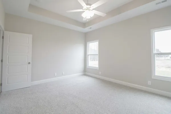 an empty room with windows and fan