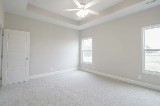 an empty room with windows and fan