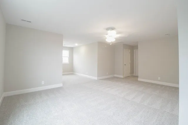 a view of an empty room with a ceiling fan