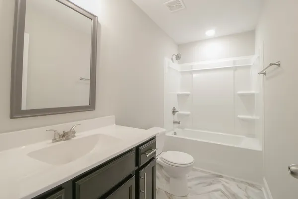 a bathroom with a granite countertop sink toilet a mirror and shower
