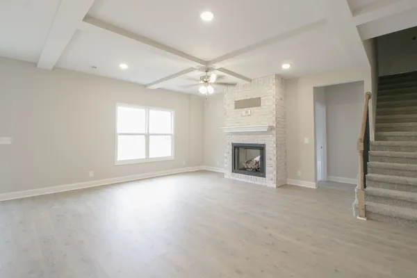 an empty room with windows and fireplace