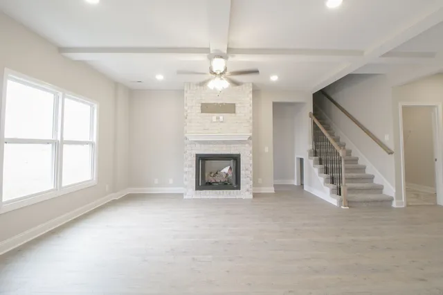 an empty room with windows and a fireplace